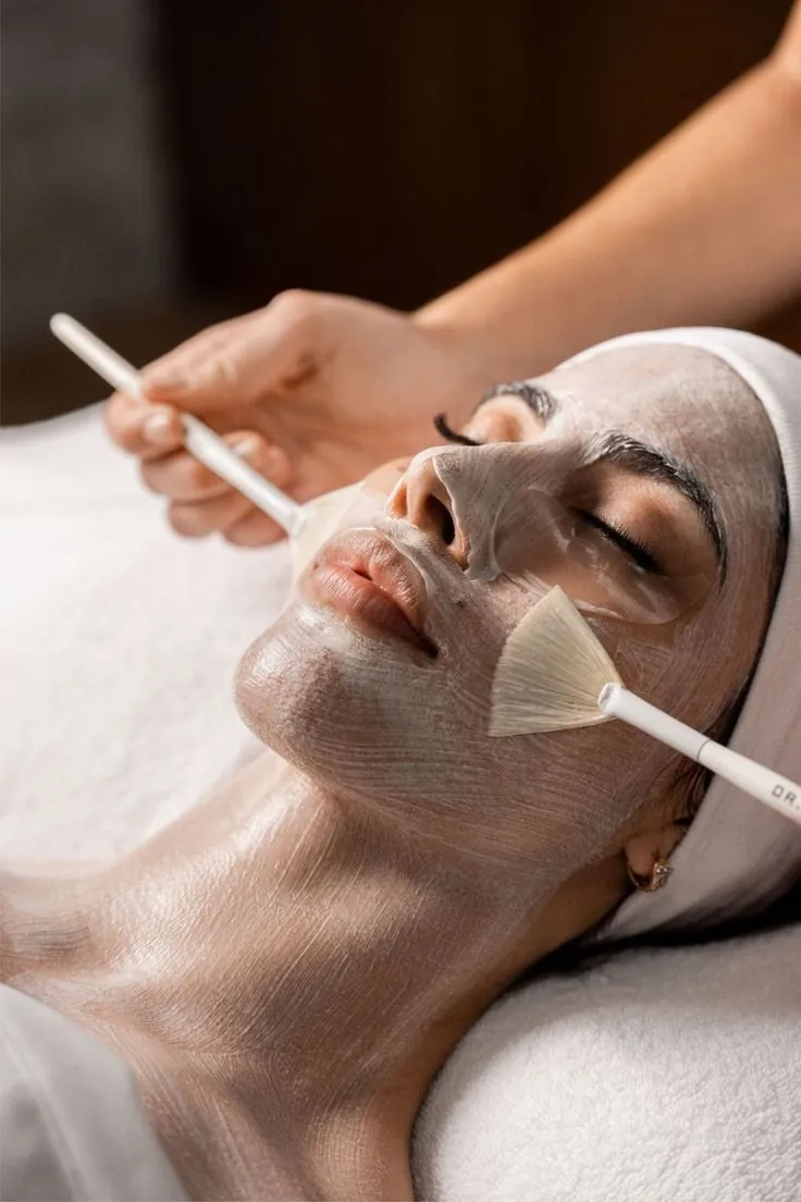 Woman receiving a medi facial with a mask applied by brush